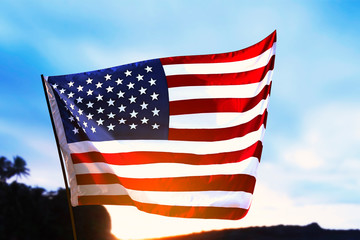 American flag waving in the air with the sunrise background