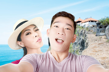 Asian couples making a selfie with a funny face on the beach