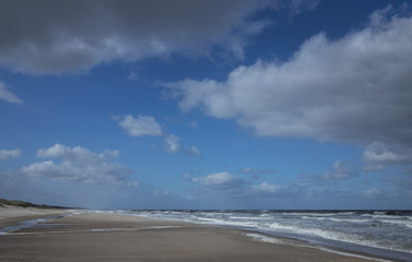 Fototapeta na wymiar Northsea coast Netherlands. Julianadorp. Beach. Breaking waves. Clouds