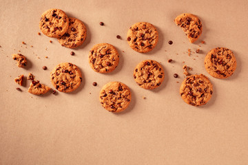 Chocolate chip cookies on a brown paper background, shot from the top with a place for text