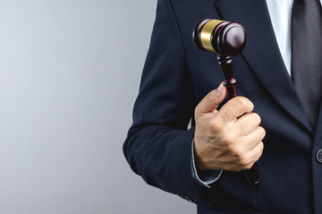 Business man hand holding wooden judge's gavel as a law or justice sign