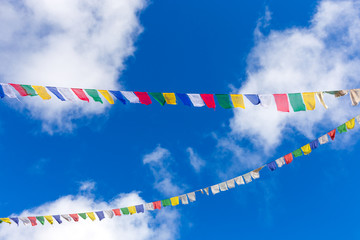 Tibetan Bhutanese prayer flags against blue sky.