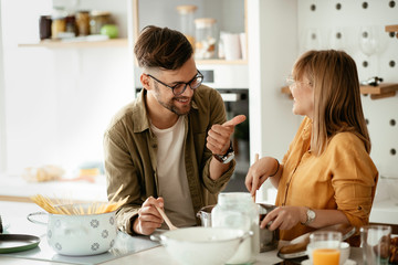 Young couple cooking together at home. Loving couple having fun while cooking.