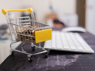 Shopping Cart With Coin On A Laptop Keyboard.