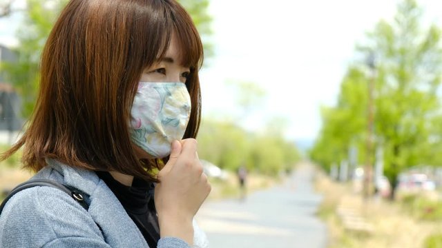 マスクの位置を調整する女性　顔を触る　無意識