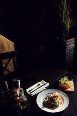 Cooked chicken legs close-up with vegetables on a plate in a restaurant.