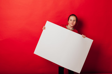 Schoolgirl's girl holds sign for inscriptions on red background