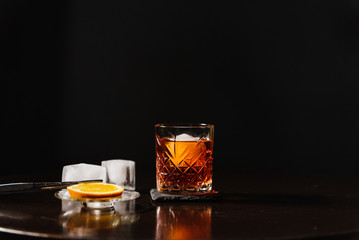 Whiskey with orange and ice close-up.
