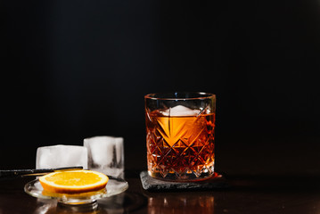 Whiskey with orange and ice close-up.