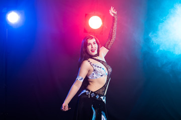 Belly dancer. Young attractive woman dancing tribal fusion on the stage. Oriental exotic dance.