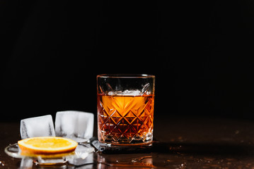 Whiskey with orange and ice close-up.