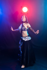 Girl dancing belly dance, fusion or tribal. A woman in a beautiful costume demonstrates charming and gentle movements in the dance.