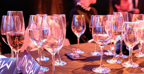 Many wine glasses on a table at a dinner party