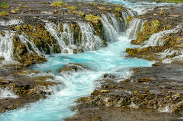 Fototapeta na wymiar The beautiful and spectacular bruarfoss waterfall in Iceland, the blue water stream in summer This is a hidden waterfall in a popular photographer secret place.