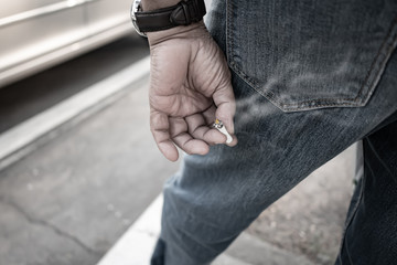 A man holding cigarette at the bottom
