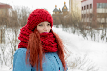 Portrait of young beautiful woman in red hat and red comforter