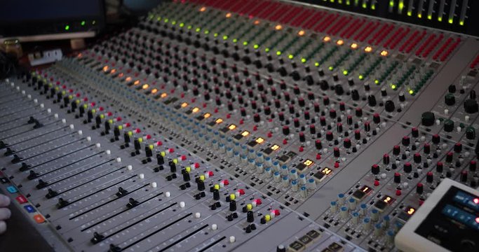 Uomo controlla il volume su mixer consolle audio professionalle vintage
