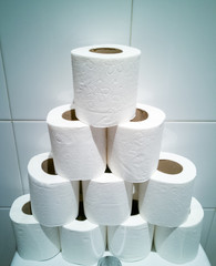 Many rolls of white toilet paper in tower