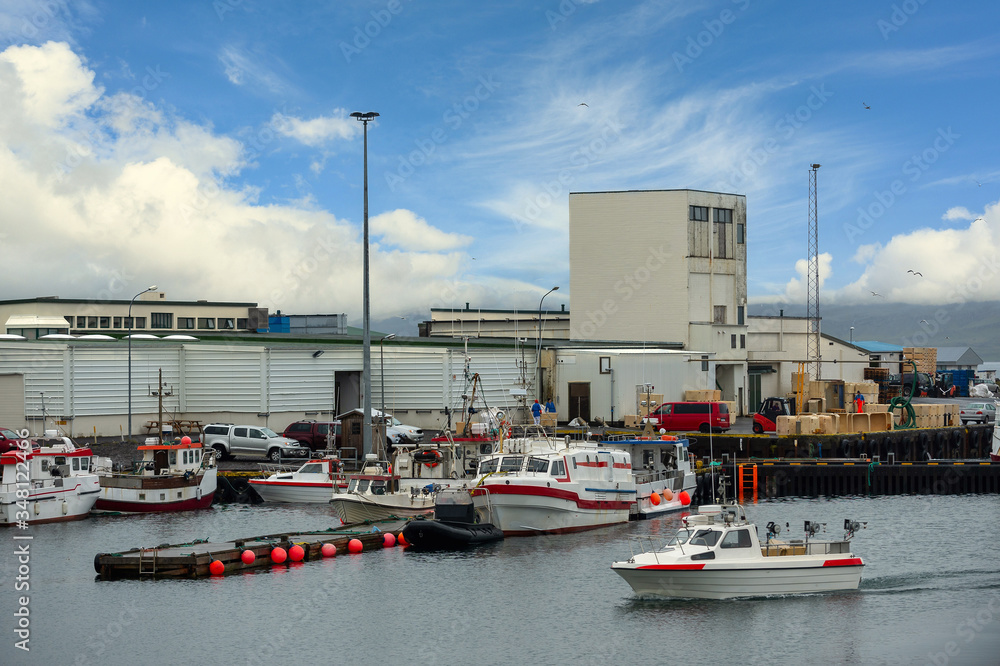 Wall mural harbor of factories and warehouses in icelandic countryside there are many boats mooring at the pier