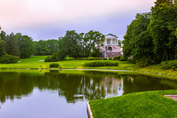 Russia. St. Petersburg. Tsarskoye Selo. Palace Catherine Park. Summer landscape. The lake among the park. Trees and buildings are reflected in the water.