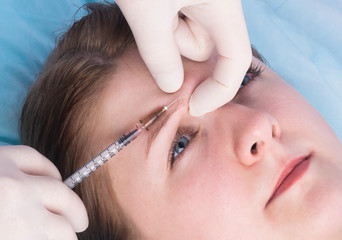 woman make cosmetic adjustments to the face area using injections