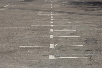 Old, dirty and fading white markings in a empty parking lot