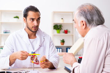 Old man visiting young male doctor cardiologist