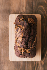 Bizcocho de chocolate horneado sobre tabla de madera sobre mesa de madera