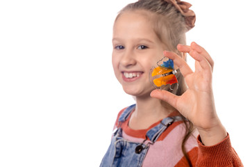 Little girl with orthodontics appliance isolated on white background.