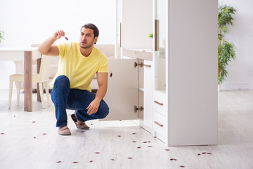 Young man and a lot of cockroaches at home