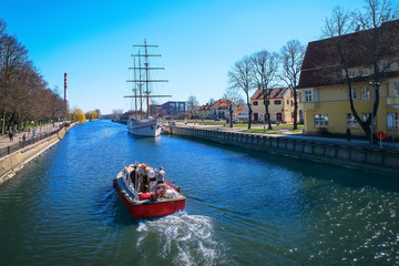 View of Dane river and sailboat or barquentine anchored in old town of Klaipeda, Lithuania