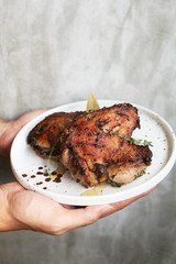 Roasted chicken with herbs on white plate