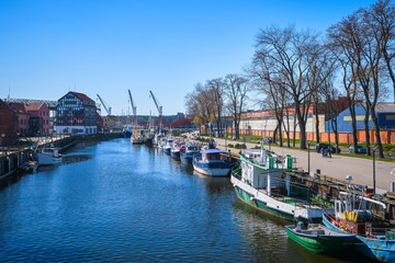 Obraz na płótnie Canvas Jetty for boats and yachts in Klaipeda, Lithuania, on sunny day. Beautiful view of vessels and fachwerk and red-brick houses