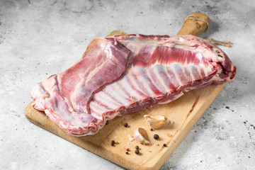 lamb ribs on a wooden Board on the light gray kitchen table. Lamb meat