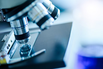 Lab microscope for research about coronavirus to develop vaccine in blue tone at laboratory,...