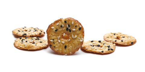 Baked pretzels with black and white sesame seeds, savory snacks isolated on white background