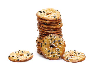 Baked pretzels with black and white sesame seeds, savory snacks isolated on white background
