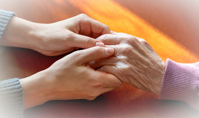 Elderly hands. Helping hands of young adult and senior women. Care and elderly concept.