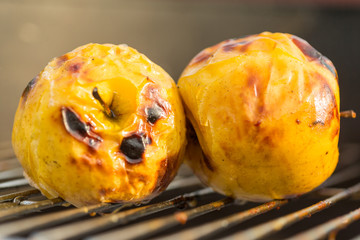 Grilled yellow apples on outdoor barbecue side view