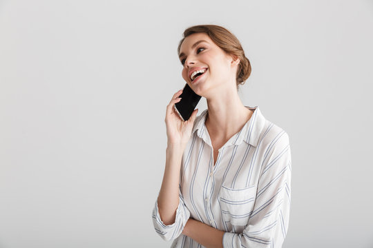 Image of joyful beautiful woman laughing and talking on cellphone