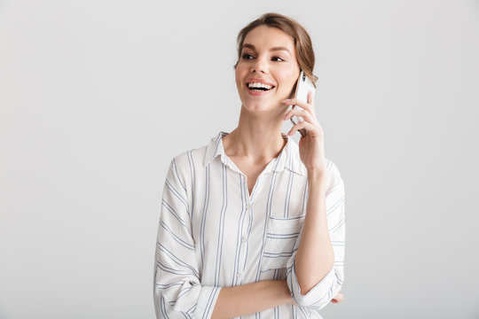 Image of joyful beautiful woman laughing and talking on cellphone