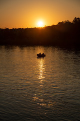 Sunset, boat, river and two men