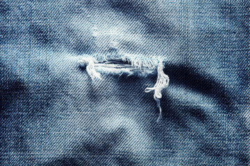 Torn or ripped old worn denim blue jeans