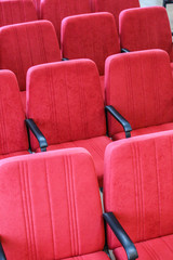 Red chair close-up.  Rows seats in empty movie theater. Conference room seating.