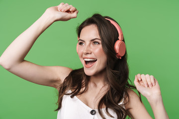 Image of cheerful nice woman dancing while using wireless headphones