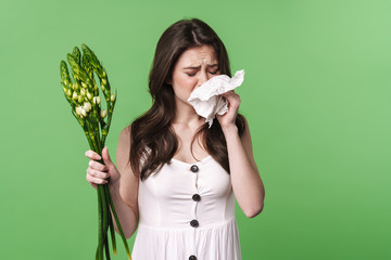 Image of unhappy woman with allergy holding handkerchief and flowers