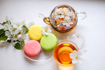 Jasmine green tea with sweet french macarons, Colorful macaroons with cup of tea and teapot. Top view.