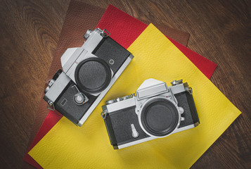 Old vintage SLR 35mm film cameras with colorful leather background