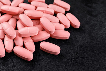 pink pills on a black background