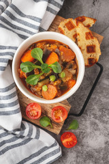 stewed vegetables in a bowl, lecho vegetarian, gray background
